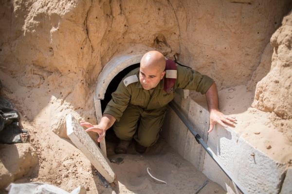 An Israeli soldier shows off a small tunnel entrance near the Gaza Strip operated by Hamas.